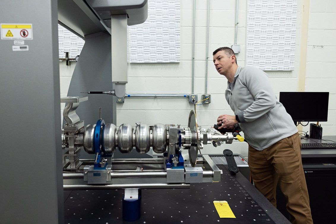 Technician inspecting a machined assembly on a metrology bench